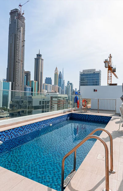 Rooftop swimming pool with city skyline at Urban Panda Hostel DWTC